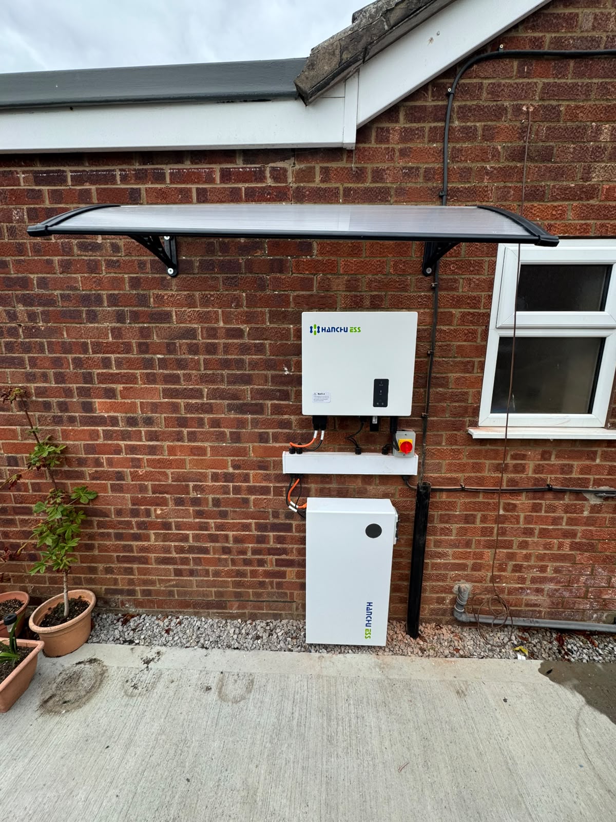 Hanchu ESS inverter and wall-mounted battery with weather canopy
